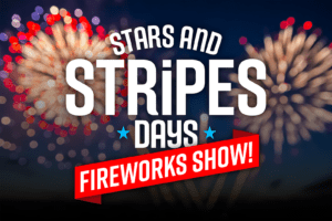 Graphic Image of White Stars & Stripes Days logo on top of photo of fireworks in the distance with a red banner with the words Fireworks Show on the top