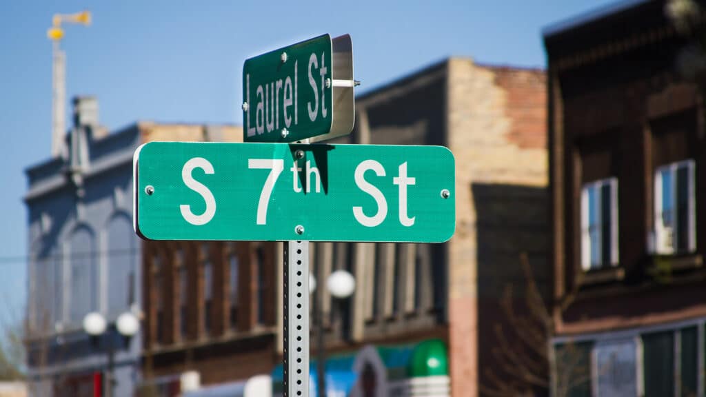 Photo of street signs for South 7th Street and Laurel Street with Brick buildings in Downtown Brainerd in background