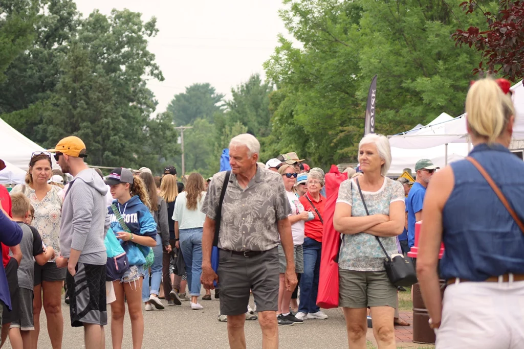 Photo of Bean Hole Days showing crowds of people walking through the park during a craft fair on a summer day